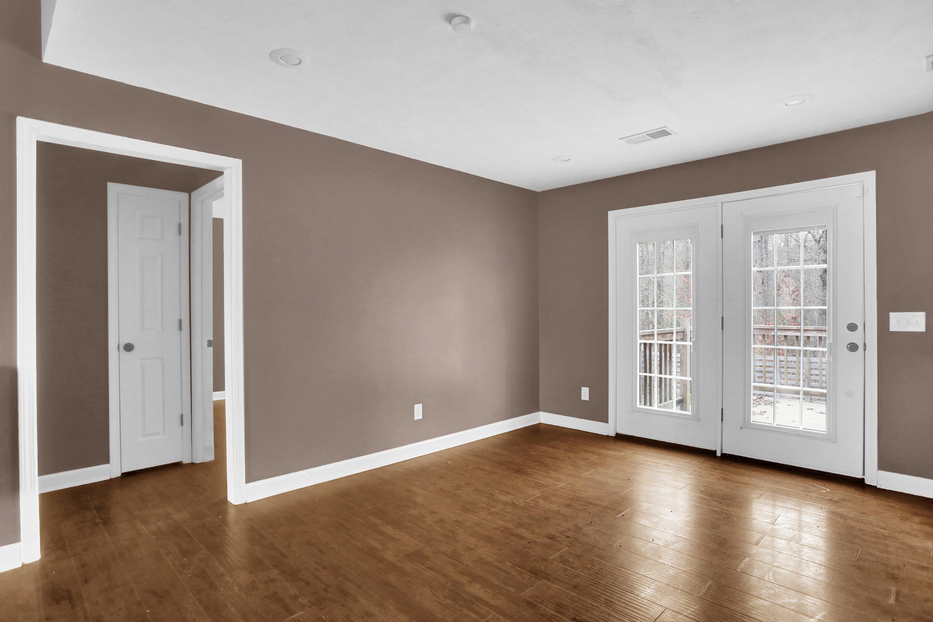 186 King Road Selmer, TN 38375 - Photo 17 of 30 an empty room with wooden floor and windows with curtains