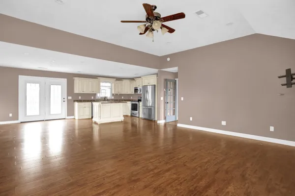 a view of an empty room with window and wooden floor