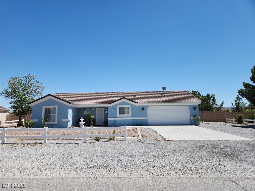 Ranch-style house with a fenced front yard, a gara