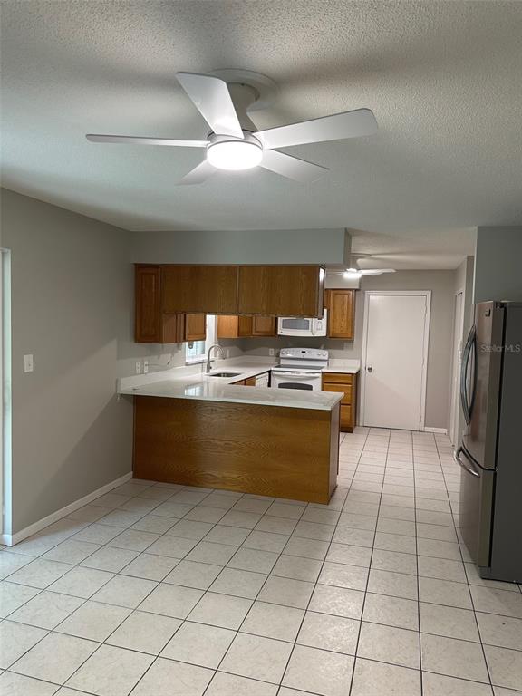 6428 Tula Lane Lakeland, FL 33809 - Photo 27 of 29 a kitchen with granite countertop a refrigerator and a stove top oven
