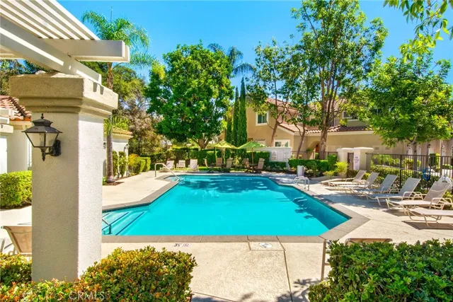 a view of a swimming pool with lawn chairs under an umbrella
