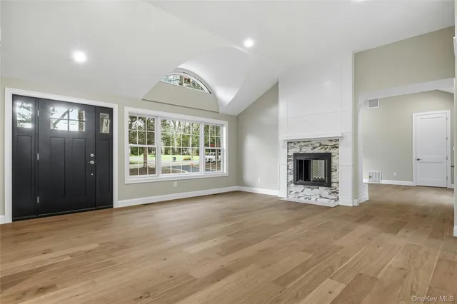 a view of an empty room with window and fire place