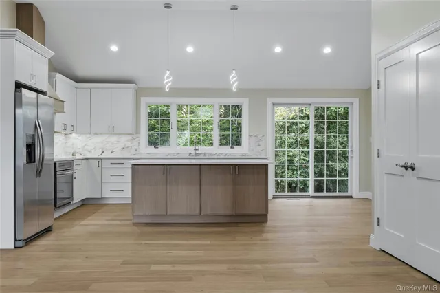 a kitchen with stainless steel appliances granite countertop a stove a sink and a refrigerator