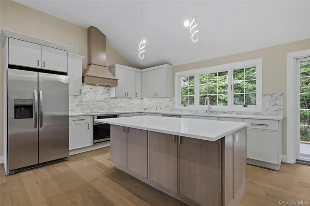 a kitchen with kitchen island granite countertop a sink cabinets and stainless steel appliances