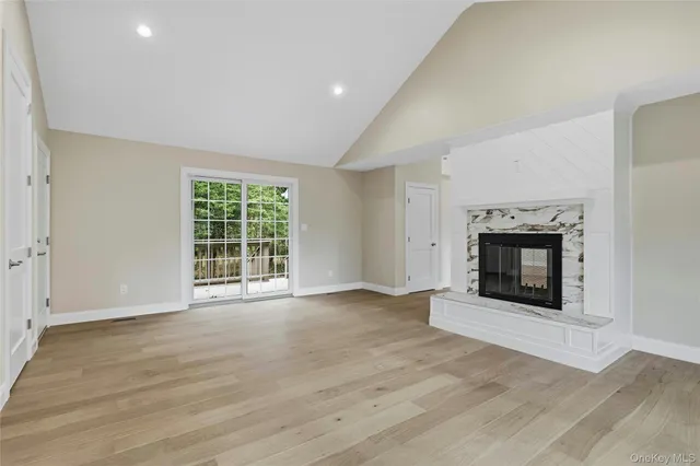 an empty room with windows and fireplace