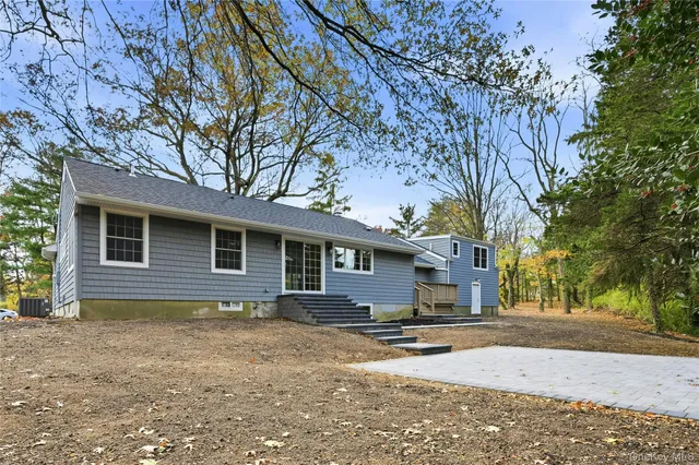 a backyard of a house with barbeque oven and large trees