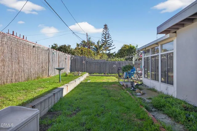 a view of backyard with table and chairs and wooden fence