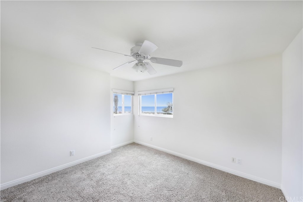 34004 Selva Road, Unit 377 Dana Point, CA 92629 - Photo 14 of 19 an empty room with a chandelier fan and windows