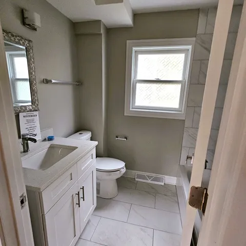 a bathroom with a sink toilet and window