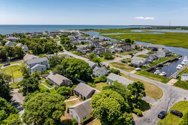 an aerial view of ocean and residential houses with outdoor space