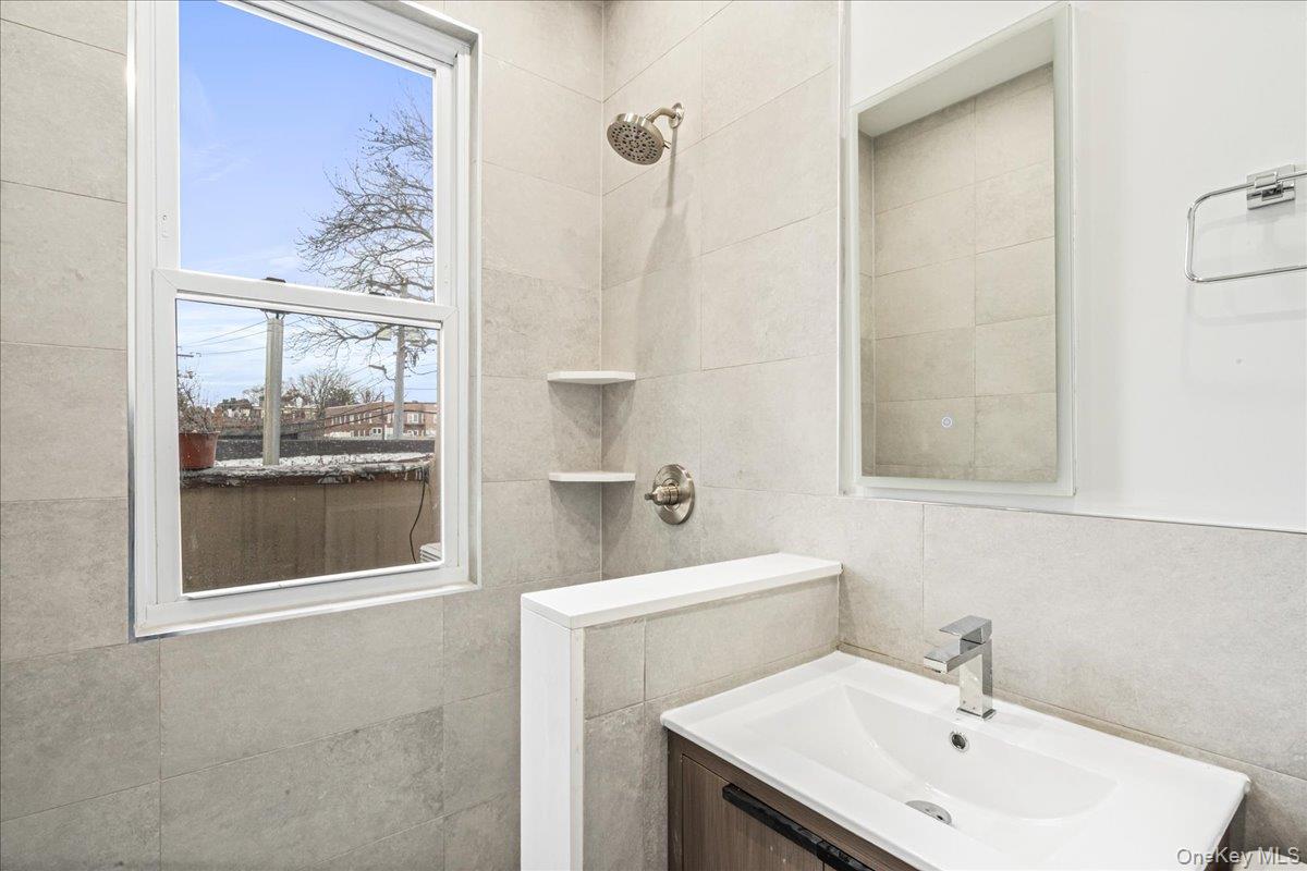 409 Plandome Road, Unit H Manhasset, NY 11030 - Photo 14 of 15 a bathroom with a sink and a mirror