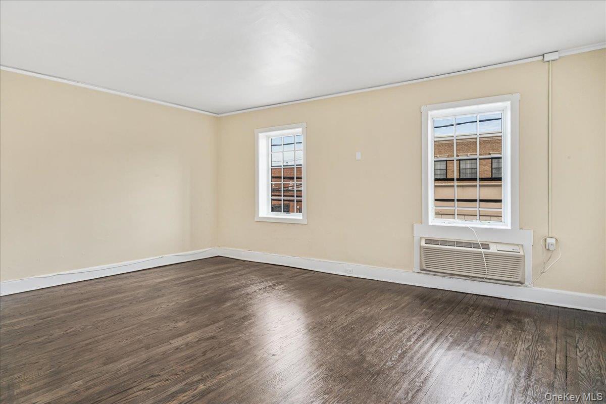 409 Plandome Road, Unit H Manhasset, NY 11030 - Photo 2 of 15 a view of an empty room with wooden floor and a window