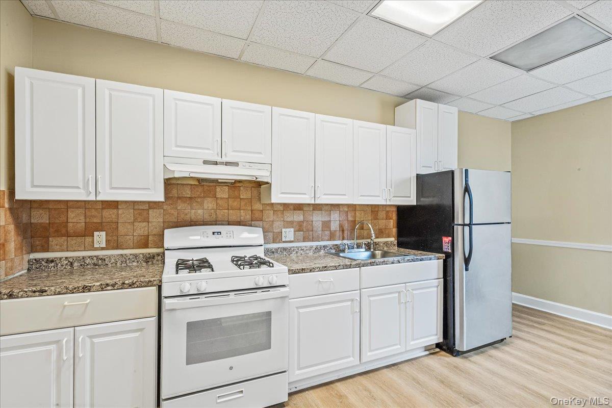 409 Plandome Road, Unit H Manhasset, NY 11030 - Photo 8 of 15 a kitchen with cabinets appliances and a counter space