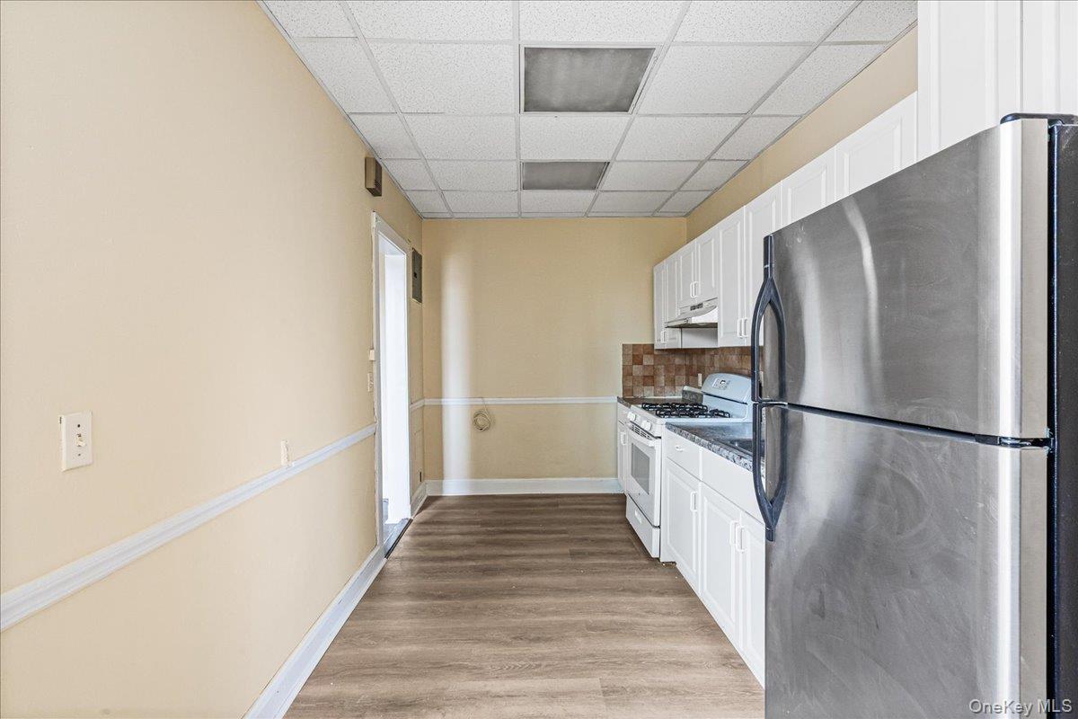409 Plandome Road, Unit H Manhasset, NY 11030 - Photo 10 of 15 a kitchen with stainless steel appliances a refrigerator sink and cabinets
