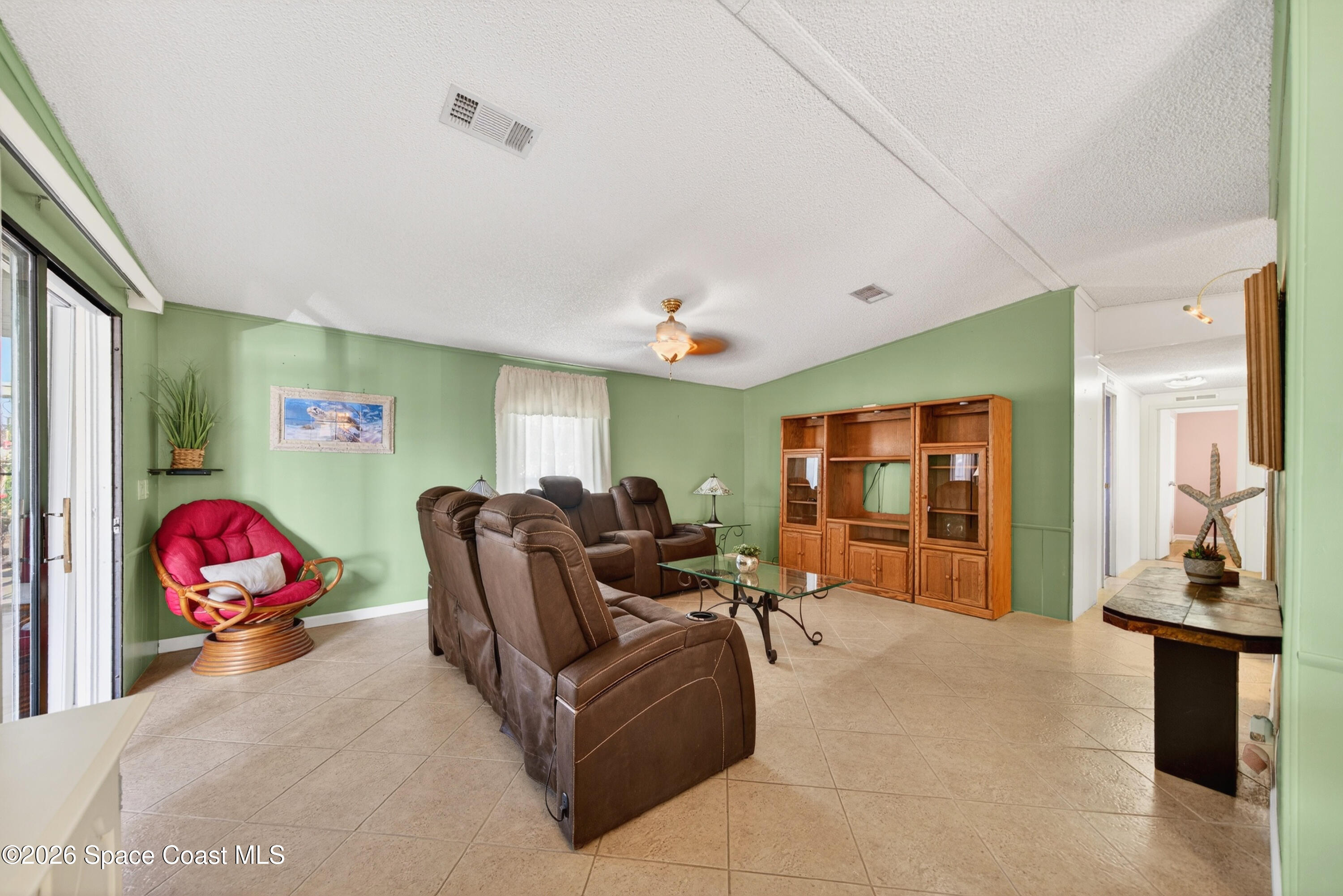 7645 Chasta Road Micco, FL 32976 - Photo 12 of 39 a living room with furniture a flat screen tv and a large window