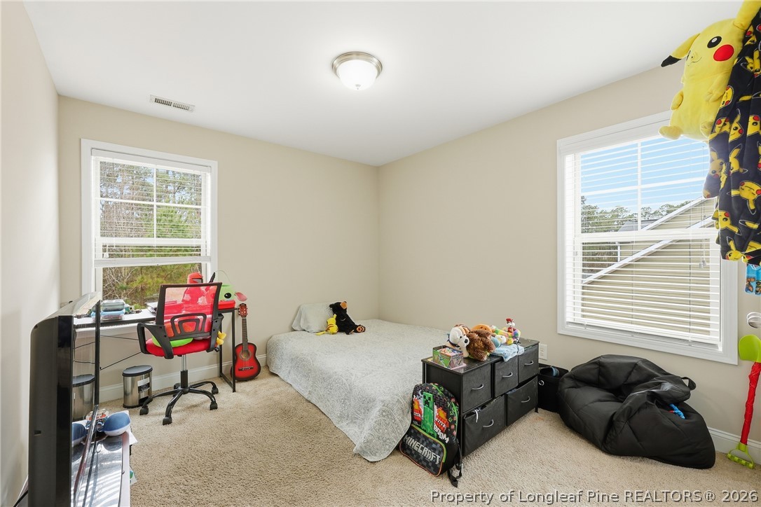 183 Cooper Creek Avenue Spring Lake, NC 28390 - Photo 19 of 34 a bedroom with a bed and windows