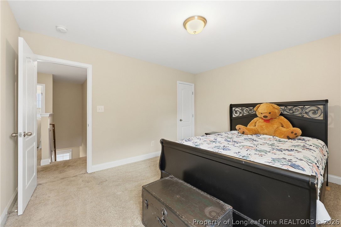 183 Cooper Creek Avenue Spring Lake, NC 28390 - Photo 22 of 34 a bedroom with a bed and lamp