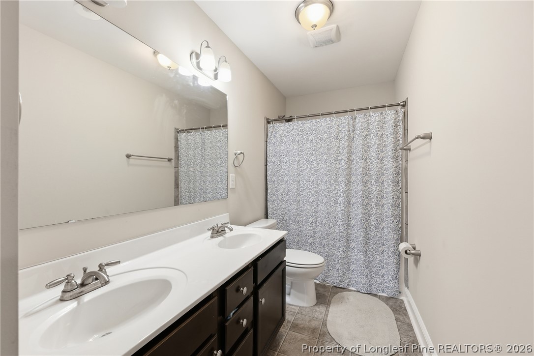 183 Cooper Creek Avenue Spring Lake, NC 28390 - Photo 23 of 34 a bathroom with a granite countertop sink toilet a mirror a vanity and shower