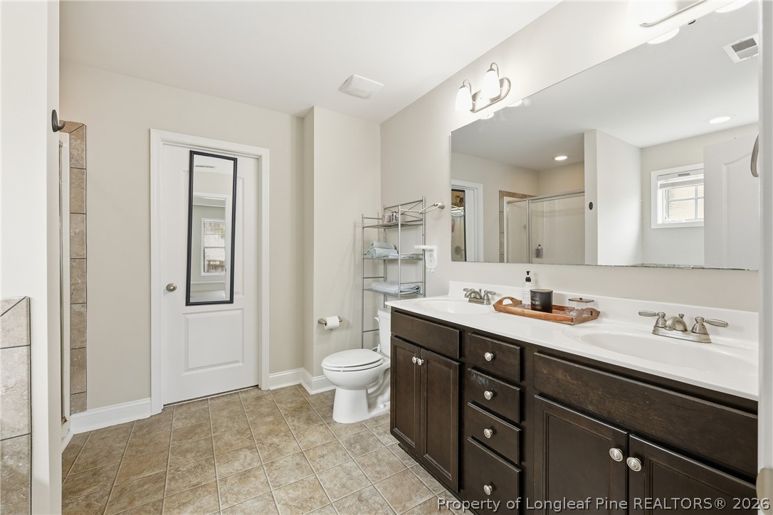 183 Cooper Creek Avenue Spring Lake, NC 28390 - Photo 26 of 34 a bathroom with a toilet sink double vanity and mirror