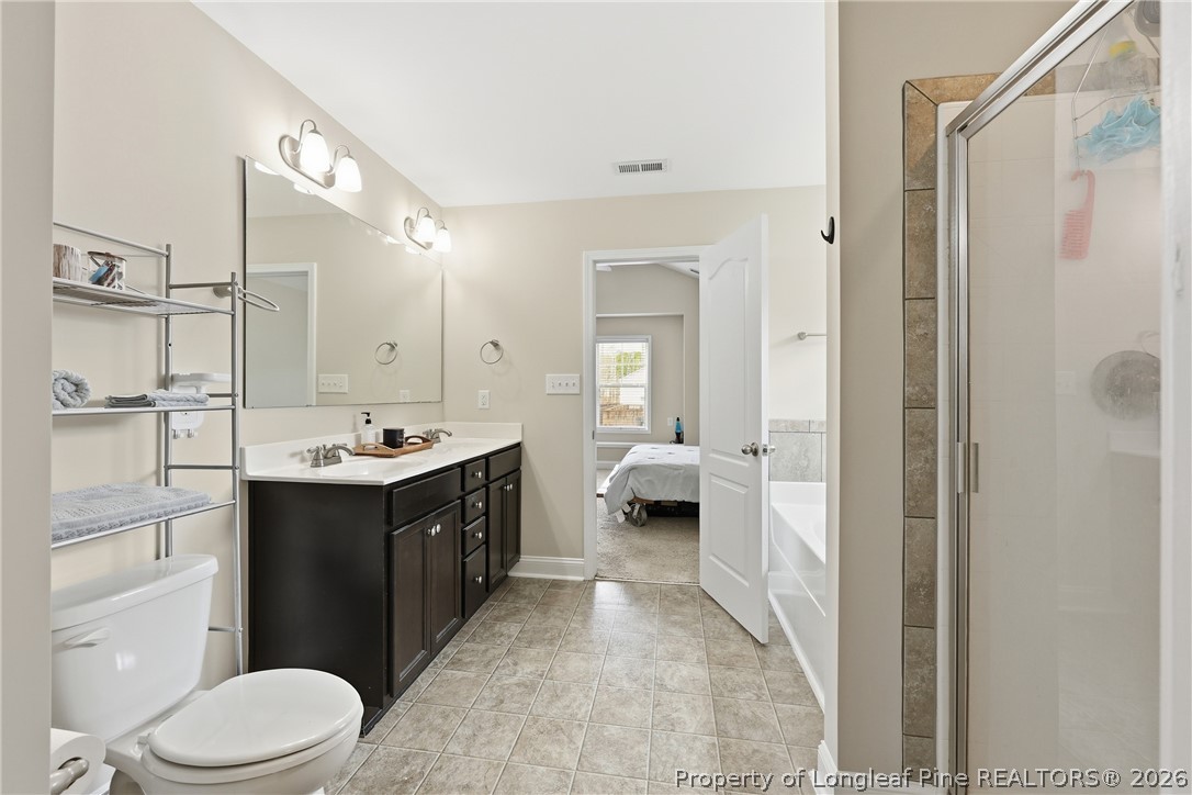 183 Cooper Creek Avenue Spring Lake, NC 28390 - Photo 27 of 34 a spacious bathroom with a double vanity sink toilet mirror and shower