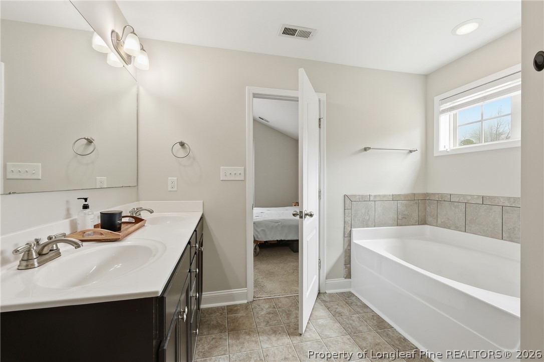 183 Cooper Creek Avenue Spring Lake, NC 28390 - Photo 28 of 34 a bathroom with a tub sink and mirror