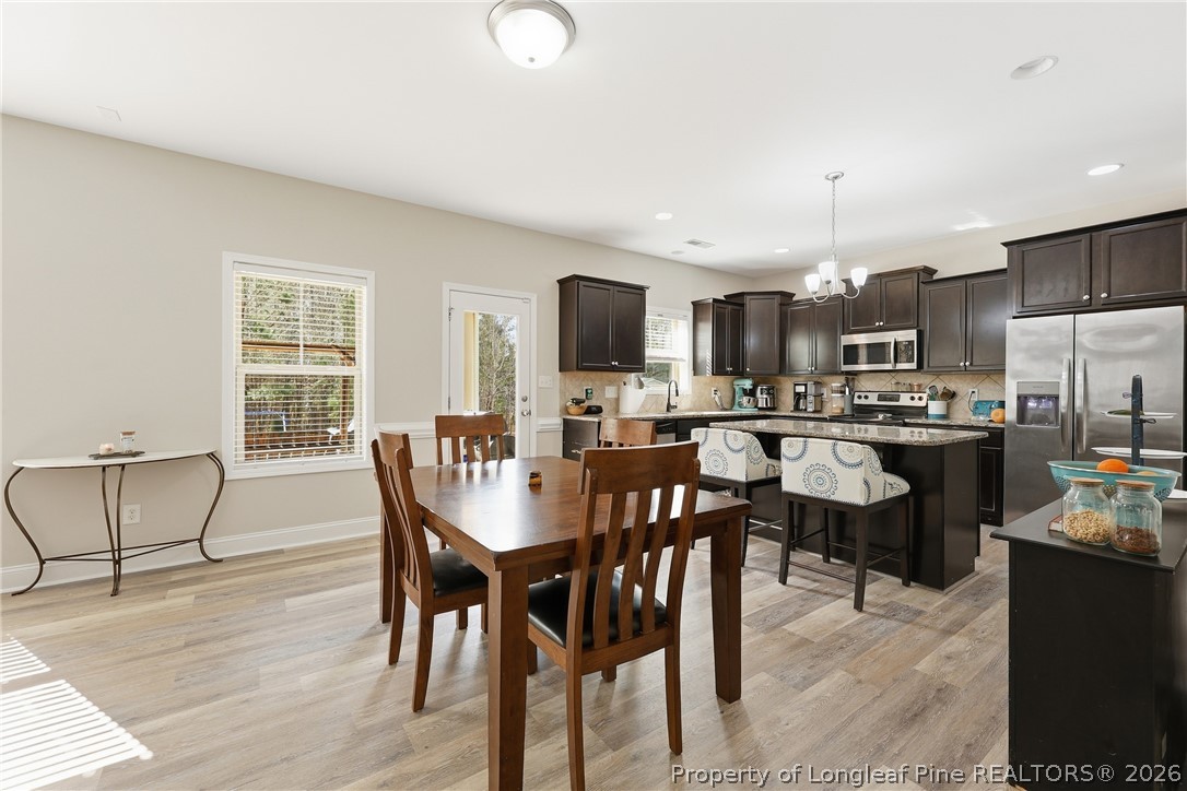 183 Cooper Creek Avenue Spring Lake, NC 28390 - Photo 10 of 34 a view of a dining room with furniture and wooden floor