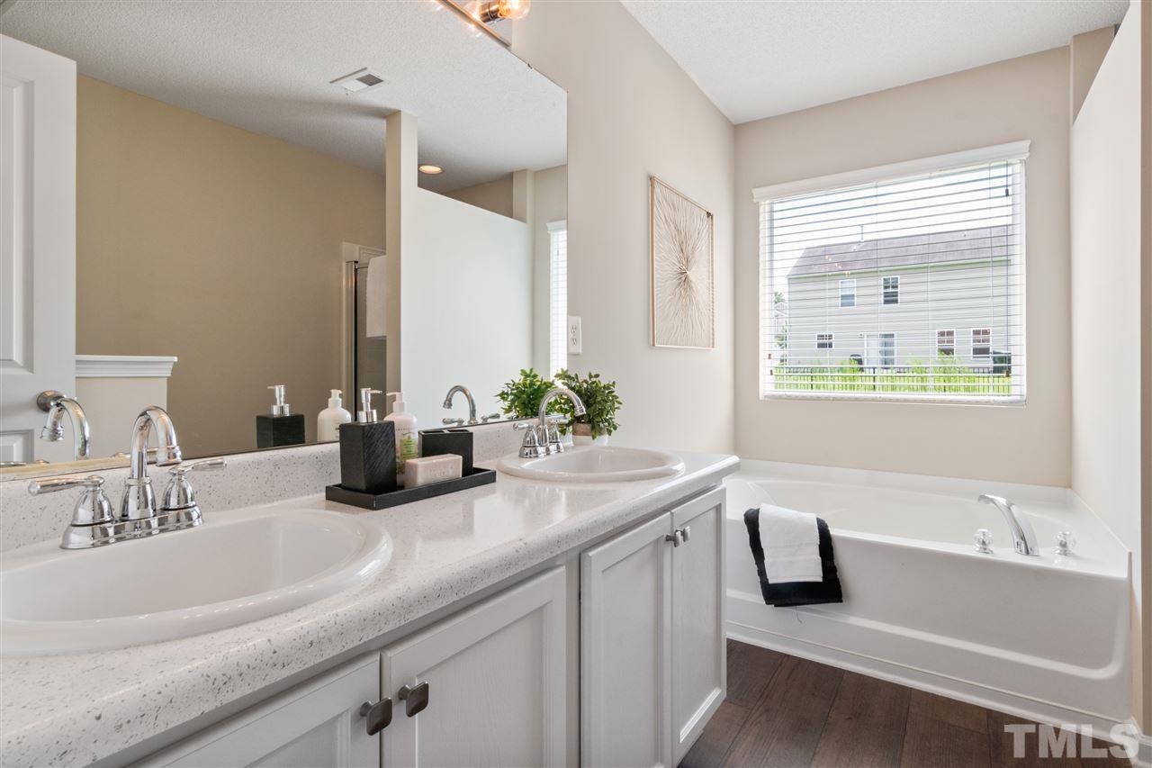 6852 Harter Court Raleigh, NC 27610 - Photo 16 of 29 a bathroom with a granite countertop sink and a bathtub