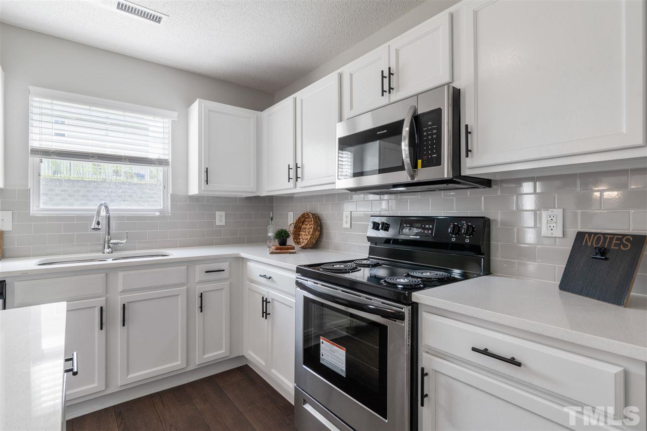 6852 Harter Court Raleigh, NC 27610 - Photo 9 of 29 a kitchen with cabinets appliances a sink and a window