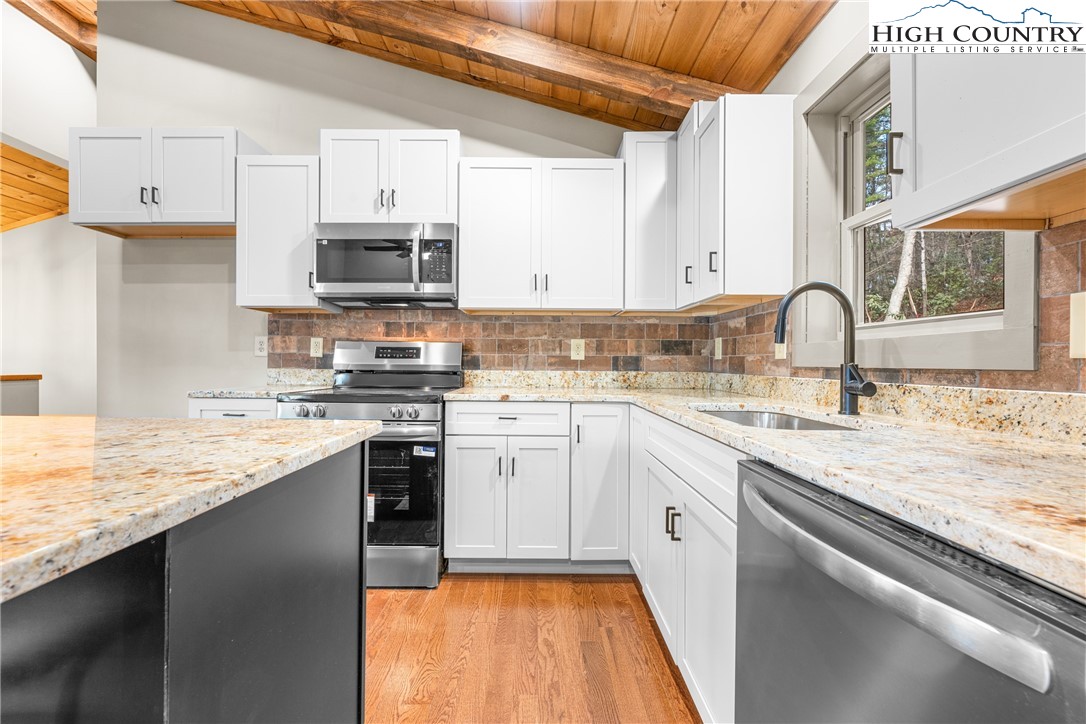 214 Ridge Run Road West Jefferson, NC 28694 - Photo 11 of 49 a kitchen with granite countertop stainless steel appliances and white cabinets