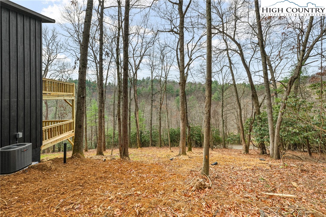 214 Ridge Run Road West Jefferson, NC 28694 - Photo 40 of 49 a backyard of a house with lawn chairs and wooden fence