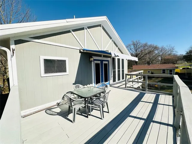 a roof deck with table and chairs and wooden floor