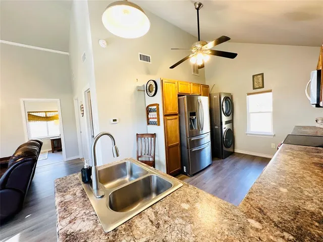 a kitchen with stainless steel appliances granite countertop a sink a stove and a refrigerator