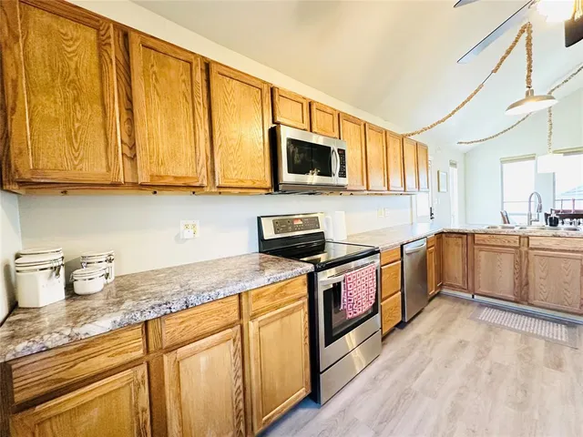 a kitchen with stainless steel appliances granite countertop a stove a sink and a microwave