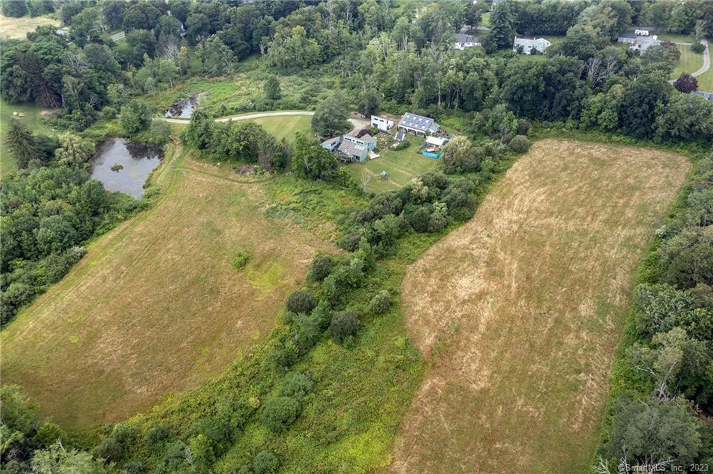 an aerial view of residential houses with outdoor space and trees