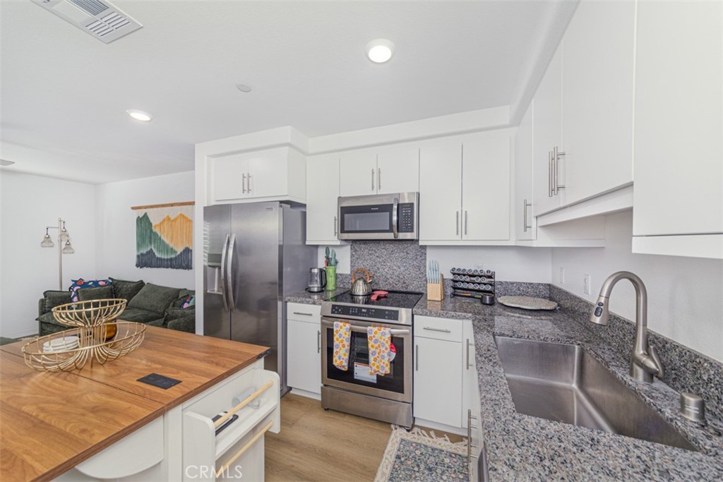 7395 Olive Grv Street Riverside, CA 92507 - Photo 9 of 18 Fully equipped kitchen with granite countertops and stainless steel appliances.