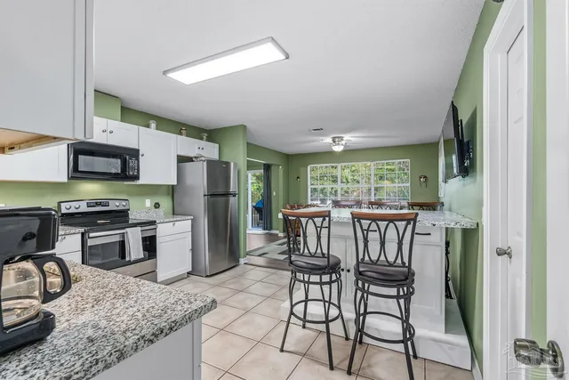 a kitchen with cabinets and chairs