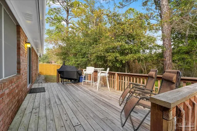 a view of deck with furniture and trees