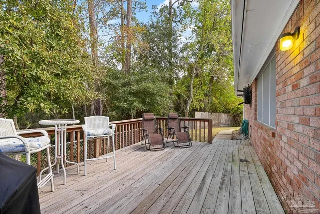 a view of wooden deck with trees in the background