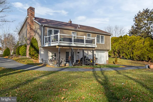 a view of a big house with a big yard and large trees