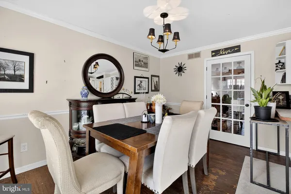 a view of a dining room with furniture a potted plant and wooden floor