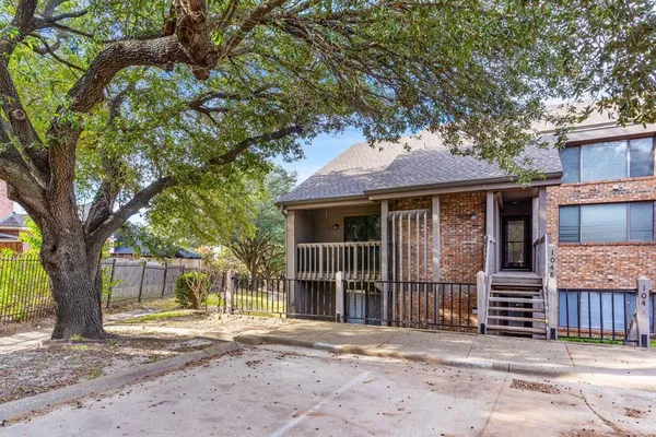 a front view of a house with a tree