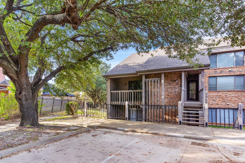 a front view of a house with a tree
