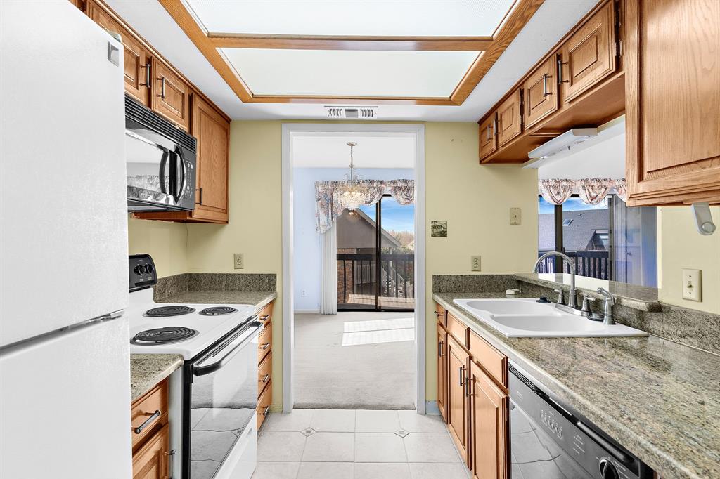 1048 Signal Ridge Place Rockwall, TX 75032 - Photo 12 of 40 a kitchen with a sink a stove and cabinets