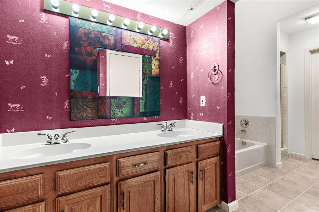 1048 Signal Ridge Place Rockwall, TX 75032 - Photo 18 of 40 a bathroom with a sink vanity and a mirror