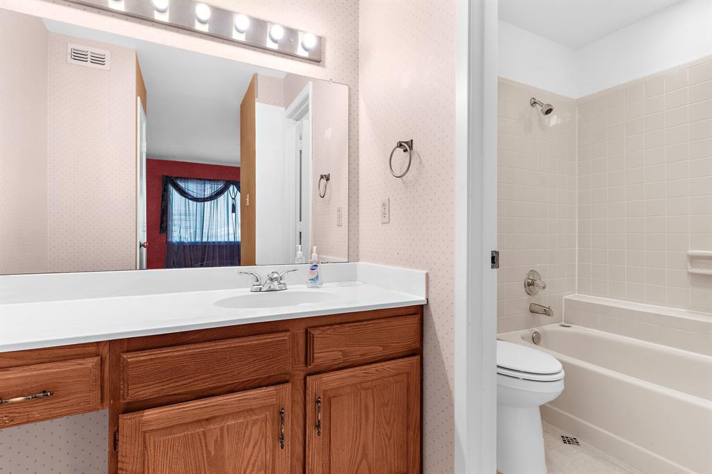 1048 Signal Ridge Place Rockwall, TX 75032 - Photo 23 of 40 a bathroom with a bathtub shower sink vanity and a mirror