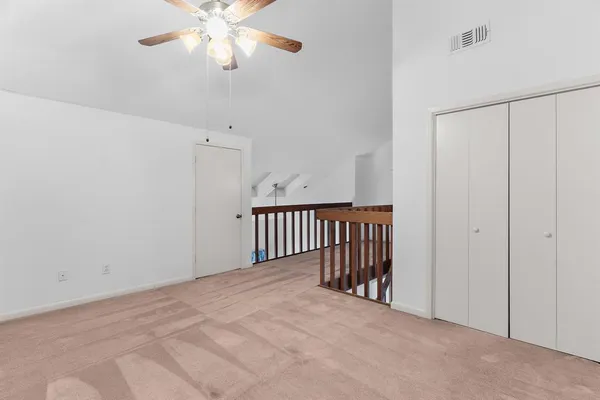 a view of a hallway with a chandelier fan