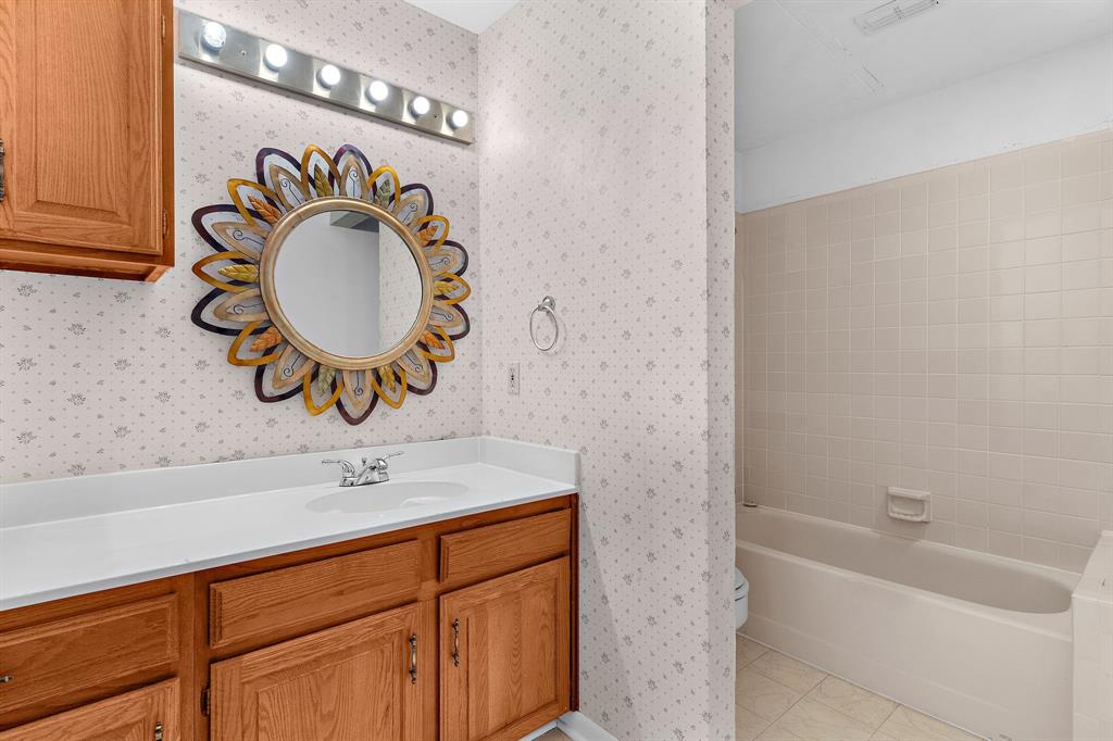 1048 Signal Ridge Place Rockwall, TX 75032 - Photo 29 of 40 a bathroom with a sink a mirror and bathtub