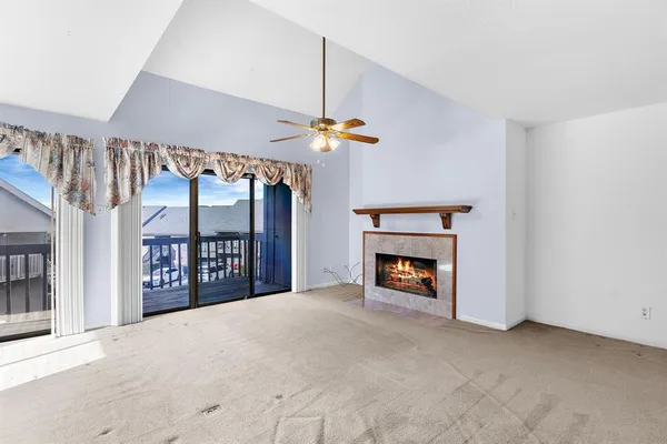 a view of an empty room with a fireplace and a window