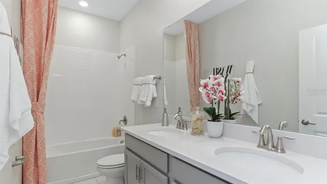 a bathroom with a granite countertop sink a toilet and shower