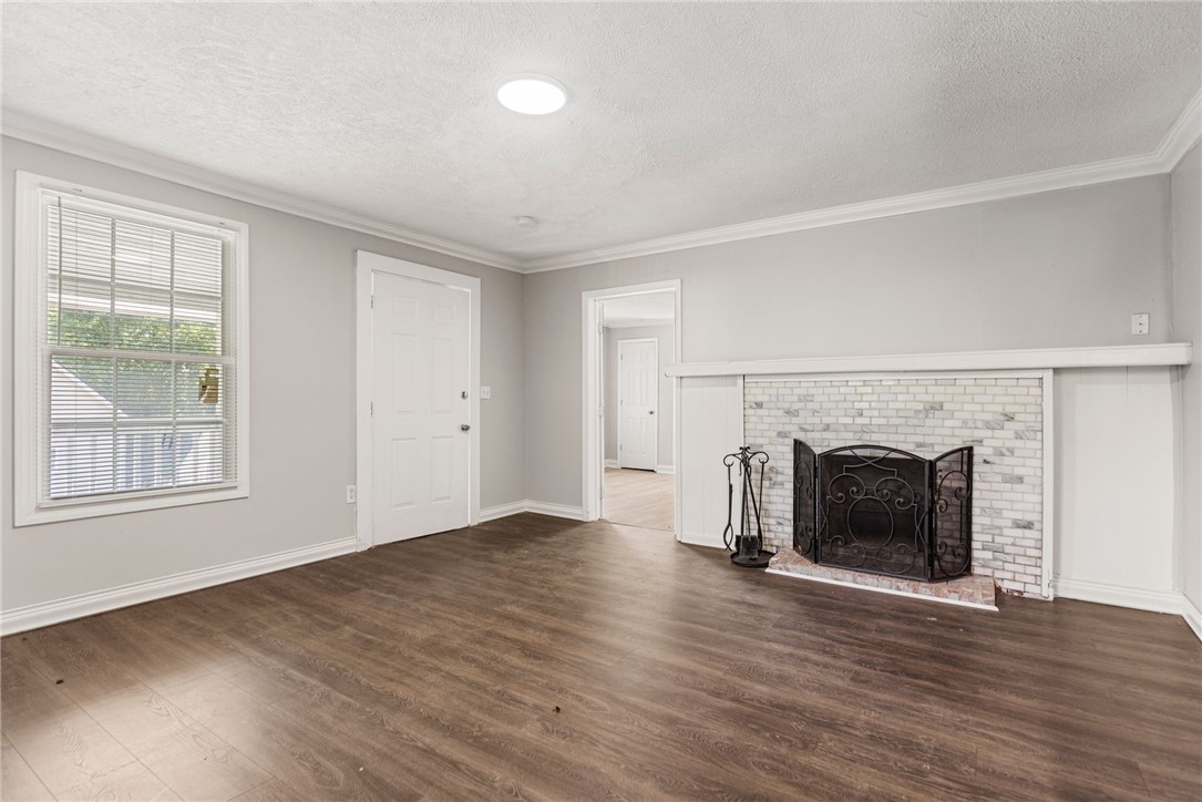 109 Farmer Street Anderson, SC 29621 - Photo 10 of 31 Hardwood-style flooring and a whitewashed brick fireplace define this inviting, naturally illuminated living space.